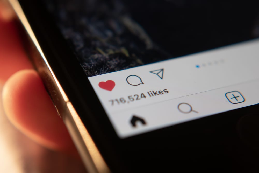 Usario visualizando likes en Instagram con pantalla móvil en primer plano