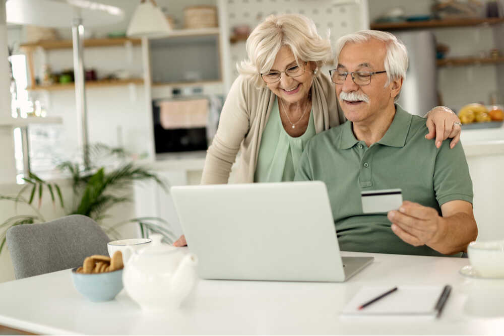 Pareja de ancianos comprando online con su portátil